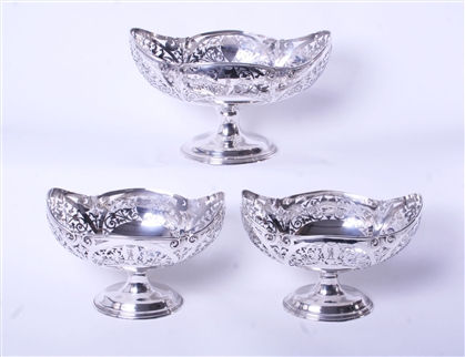 An impressive set of three Edwardian sterling silver fruit baskets