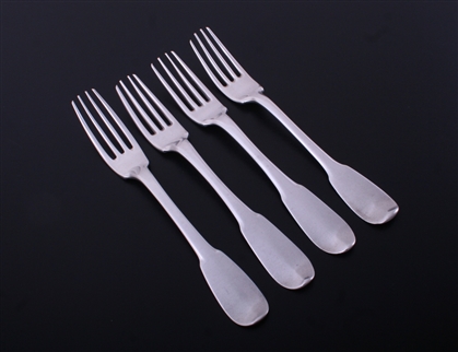 A matched set of four 18th century French provincial fiddle pattern armorial silver table forks